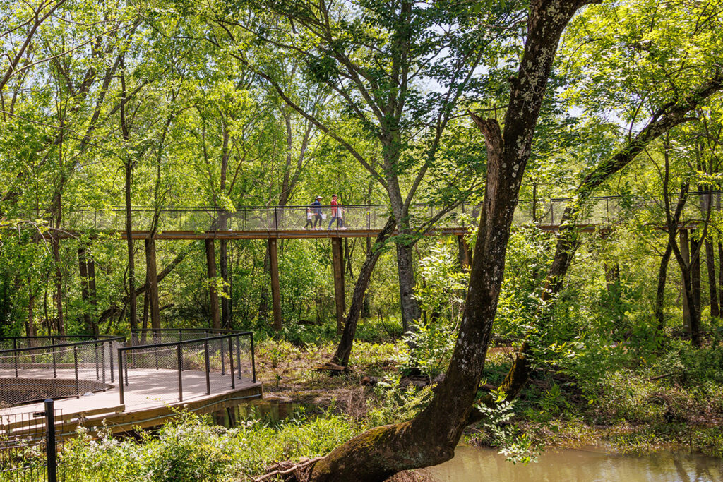 A family walks atop the elevated boardwalk at the Chattahoochee Nature Center