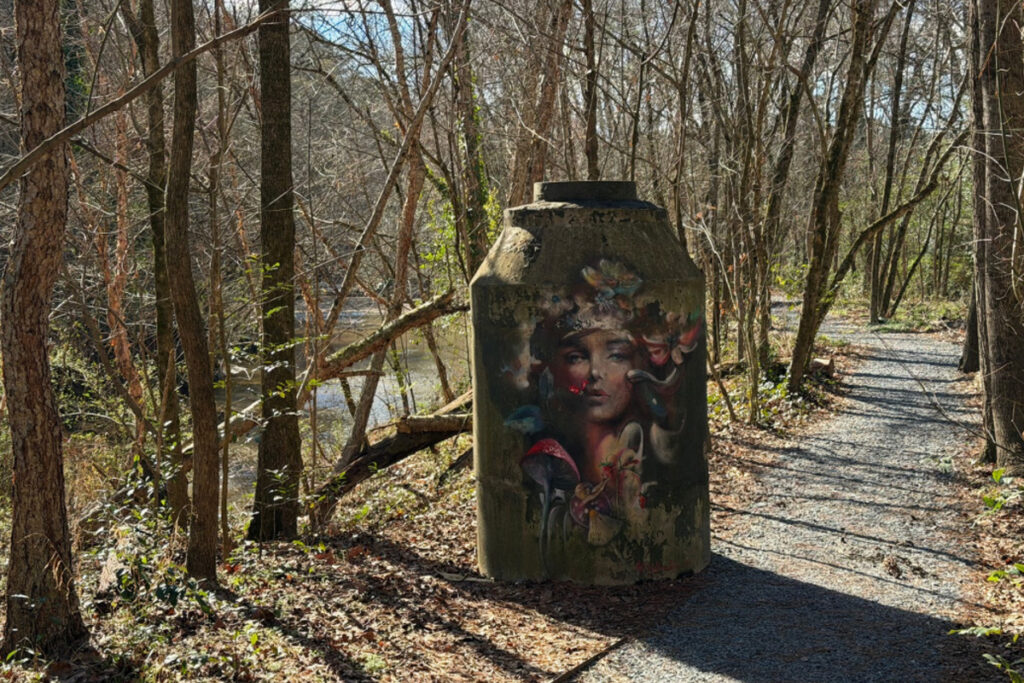 A mural of a woman surrounded by nature along the trail.